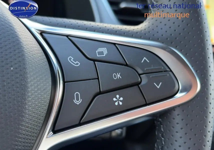 Gros plan sur les commandes multifonctions noires du volant perforé d’un Renault Captur 2026 toit noir Rafale.