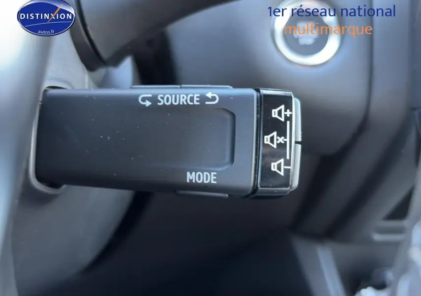 Gros plan sur la commande audio au volant du Renault Captur 1.8 e-tech hybride, intérieur noir.