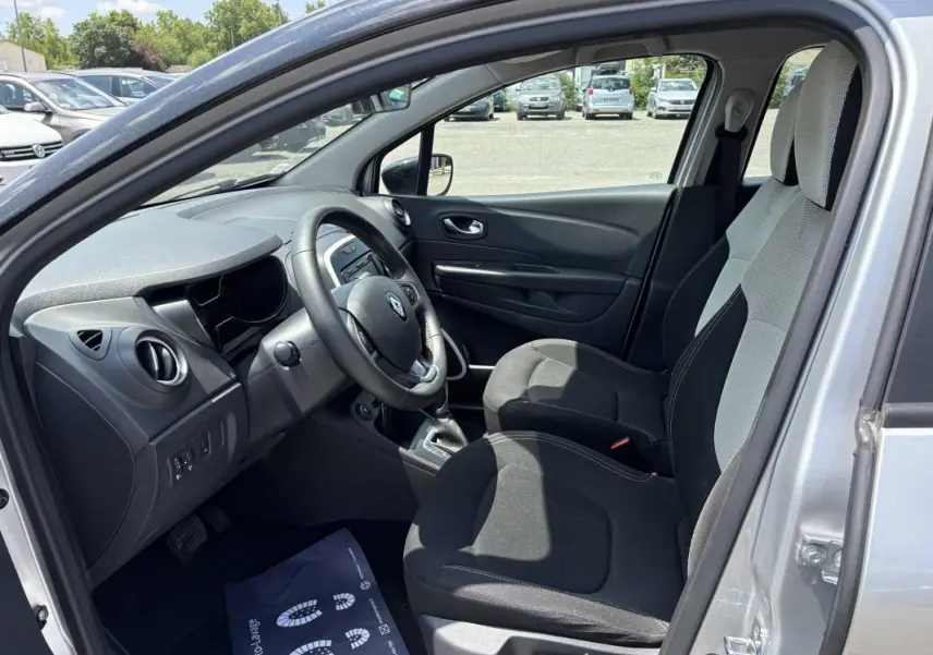 Vue intérieure côté conducteur du Renault Captur gris 2017, montrant le tableau de bord et les sièges avant.
