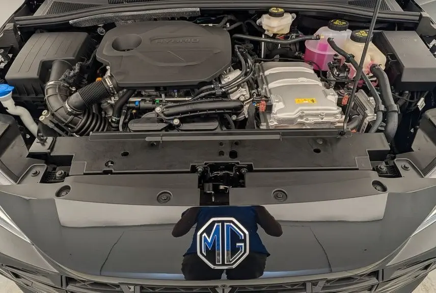Vue plongeante sur le moteur hybride du MG3 1.5L HYBRID+ 195CH Luxury en Pebble Black Metal avec capot ouvert.