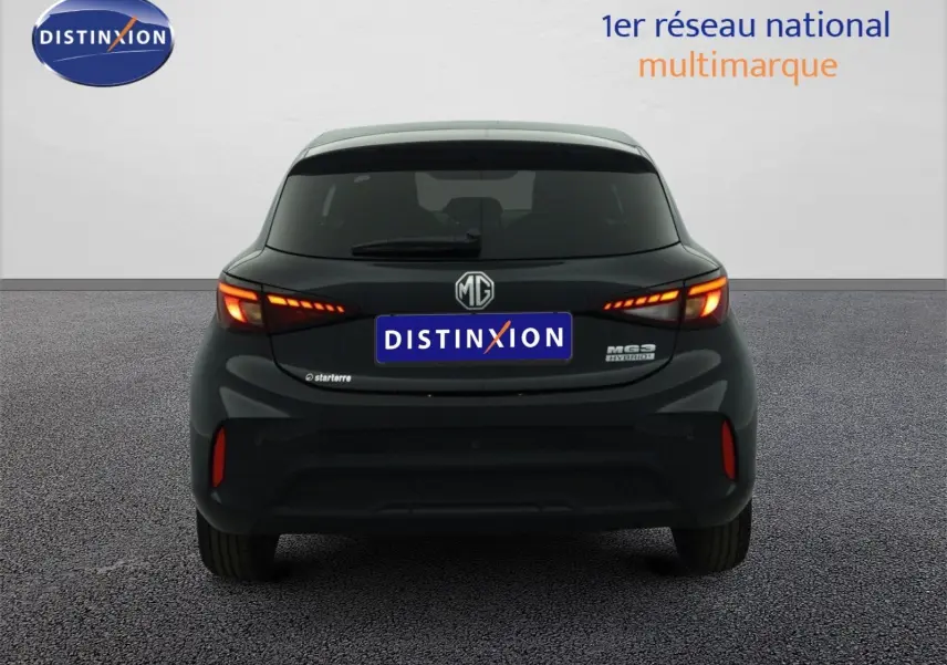 Vue arrière d'une MG3 1.5L Hybrid+ 195CH Luxury en Pebble Black Metal avec feux allumés sur fond neutre.