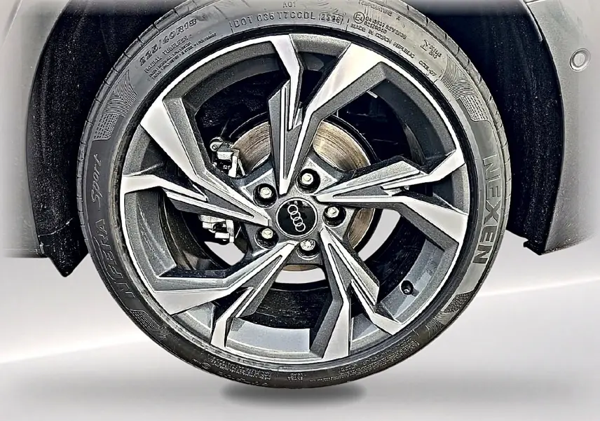 Gros plan sur la jante alu 18 pouces gris graphite de l'Audi A3 Sportback 2026 gris Daytona, avec logo Audi central.