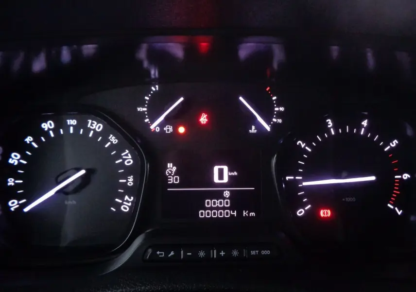 Tableau de bord éclairé du FIAT Scudo Fourgon blanc, affichant 0 km/h et 4 km au compteur, avec voyants allumés.