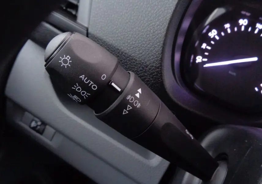 Gros plan sur la commande des phares et clignotants du tableau de bord du Fiat Scudo Fourgon blanc 2022.