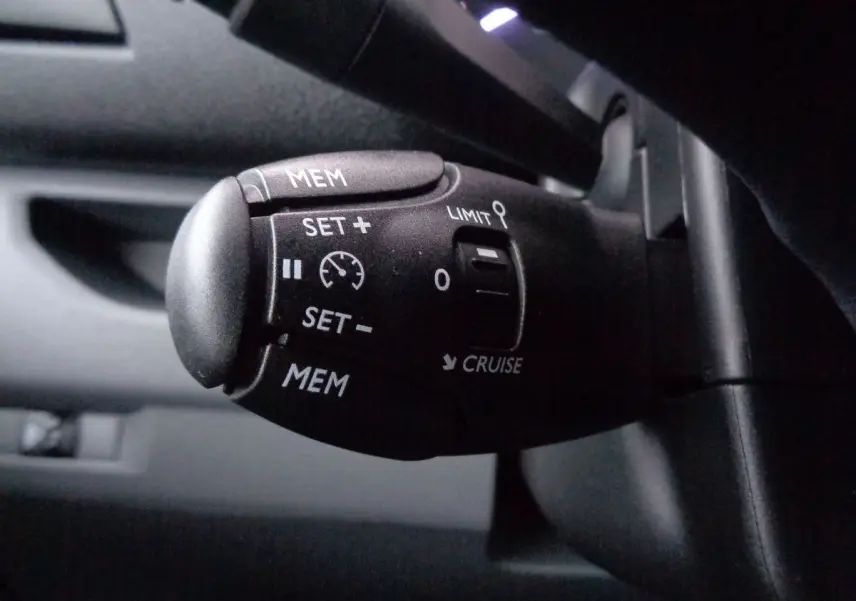 Gros plan sur la commande de régulateur de vitesse du FIAT Scudo Fourgon blanc, version 2022, intérieur noir.