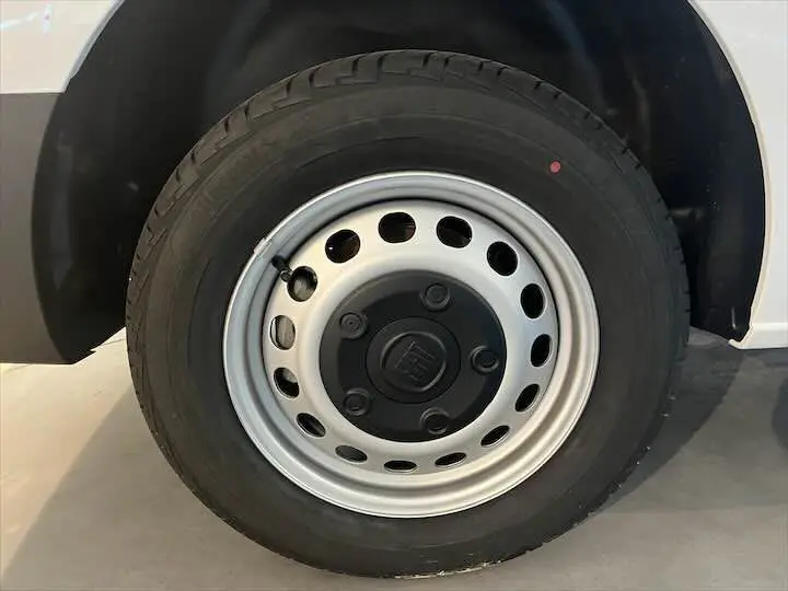 Gros plan sur la roue avant droite du FIAT Scudo Fourgon blanc avec jante acier et logo central noir.
