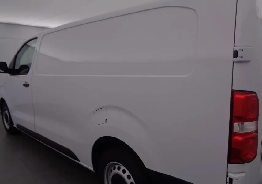 Vue latérale droite d'un fourgon FIAT Scudo blanc, mettant en valeur la carrosserie lisse et les feux arrière rouges.