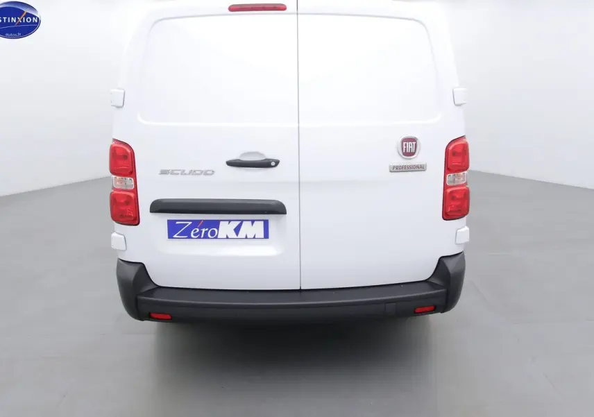 Vue arrière du FIAT Scudo Fourgon blanc avec logo et plaque Zéro KM dans un studio lumineux.