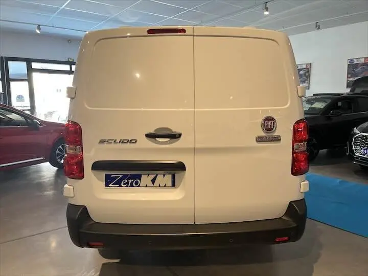 Vue arrière d'un fourgon blanc FIAT Scudo Long 2.0 MJT 145 ch Pro Lounge avec logo et plaque Zero KM visible.