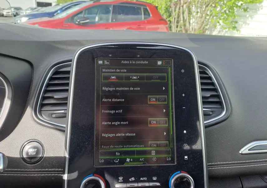 Vue rapprochée de l’écran tactile central du Renault Scenic IV gris platine, affichant les aides à la conduite.