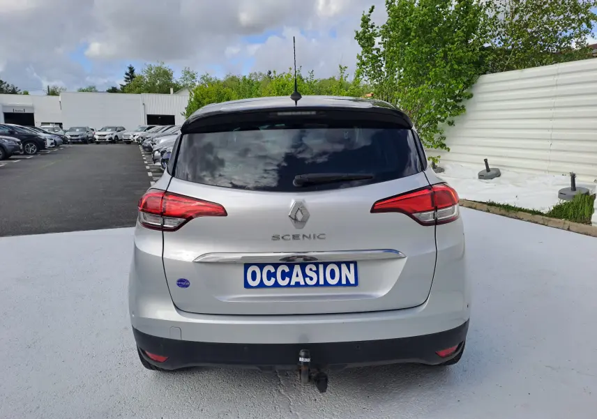 Vue arrière d'un Renault Scénic IV gris platine avec toit noir, plaque "OCCASION" et attelage visible.