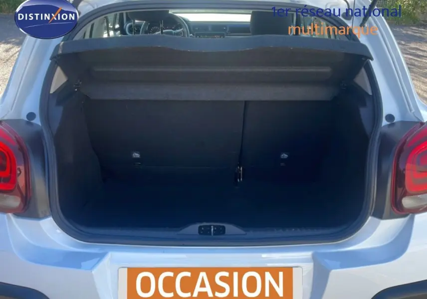 Coffre ouvert vu de l'arrière d'une Citroën C3 blanche Banquise, montrant l'espace de chargement vide.