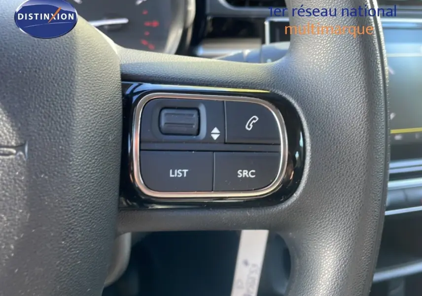 Gros plan sur les commandes au volant noir de la Citroën C3 1.5 BlueHDi 2020, côté gauche, avec boutons de gestion audio et téléphone.