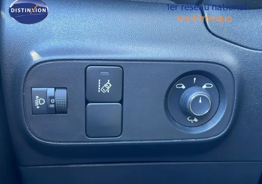 Gros plan sur les commandes noires de réglage des rétroviseurs et des phares dans une Citroën C3 blanc banquise de 2020.