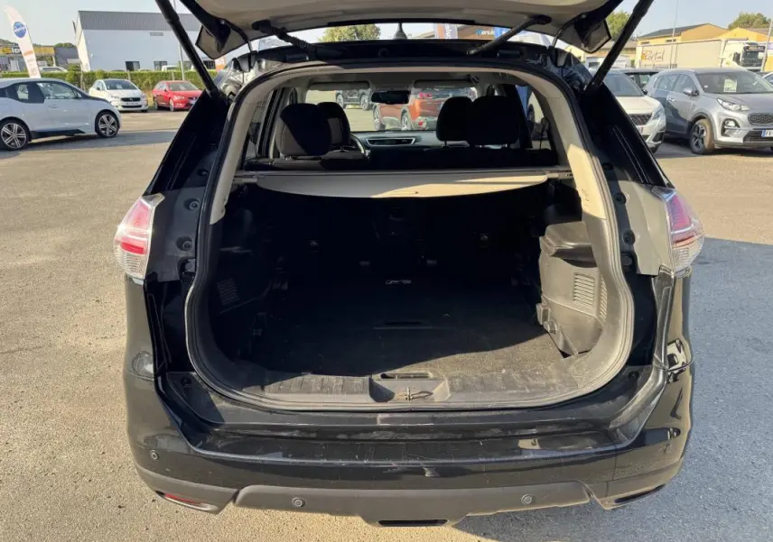 Vue arrière du coffre ouvert d'un Nissan X-Trail noir 2017, montrant l'espace de chargement et l'intérieur sombre.