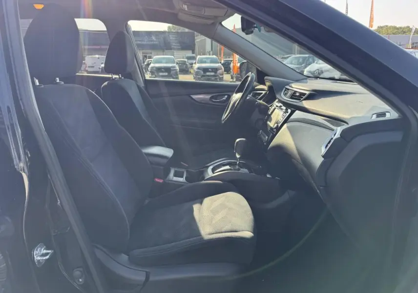 Intérieur noir du Nissan X-TRAIL 2017 vu côté conducteur, mettant en valeur les sièges et la console centrale.