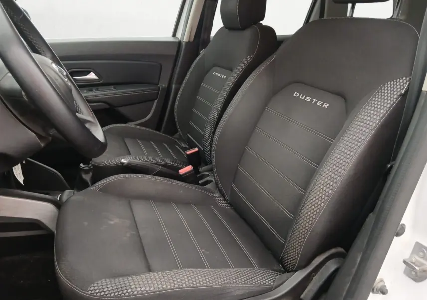 Profil côté gauche d'un Dacia Duster blanc 2021, version 4x2 Prestige avec jantes alliage noires et toit noir.