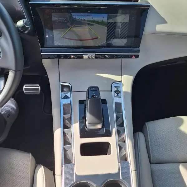 Vue intérieure centrée sur la console centrale beige du DS7 E-Tense 225 avec écran tactile affichant la caméra de recul.