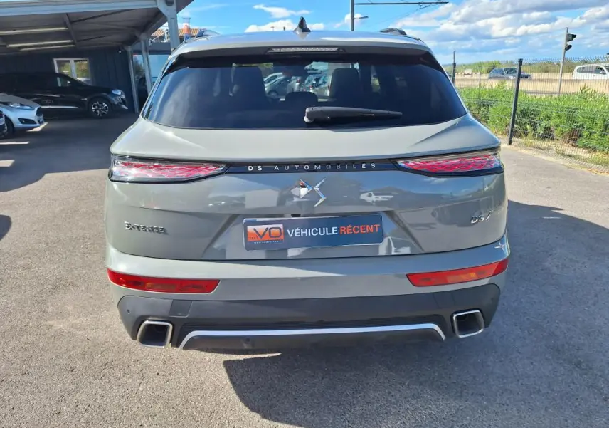Vue arrière du DS7 gris 2024 avec feux LED étirés et double sortie d'échappement carrée visible.