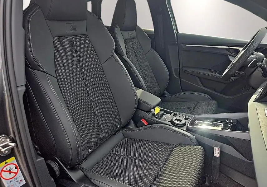 Intérieur avant d'Audi A3 Sportback 2026, vue côté conducteur, sièges sport noirs avec surpiqûres blanches et logo S.
