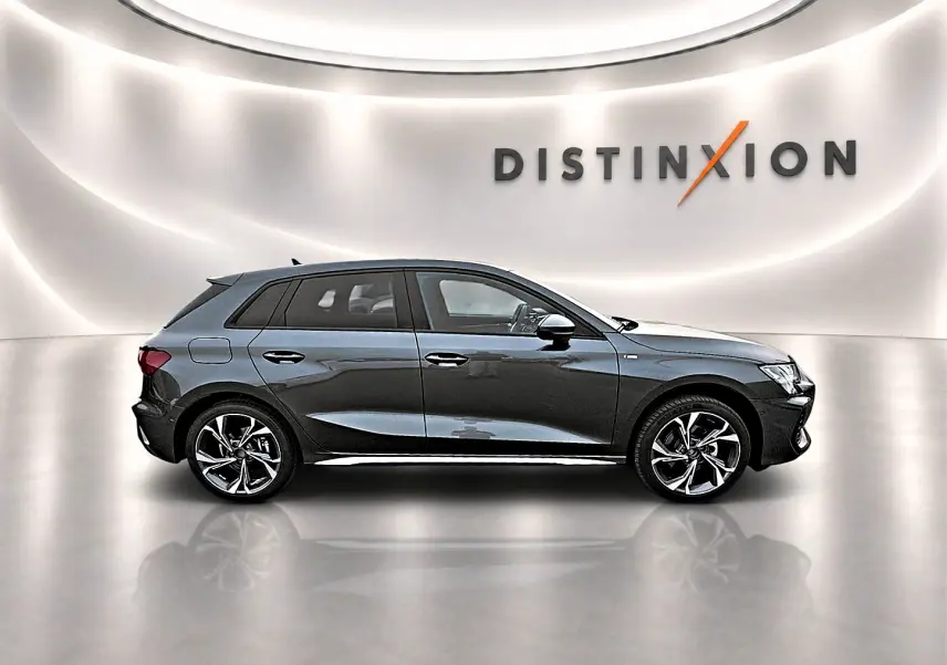 Audi A3 Sportback gris Daytona vue de profil côté gauche dans un studio lumineux avec jantes alu distinctives.