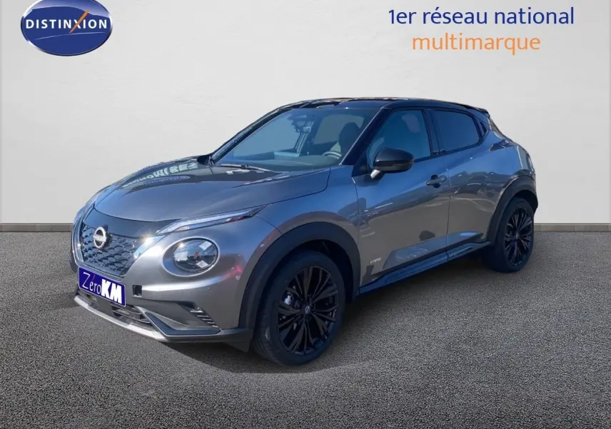 Nissan Juke 2025 gris squale métal avec toit noir, vue 3/4 avant droit, jantes noires et lignes sportives.