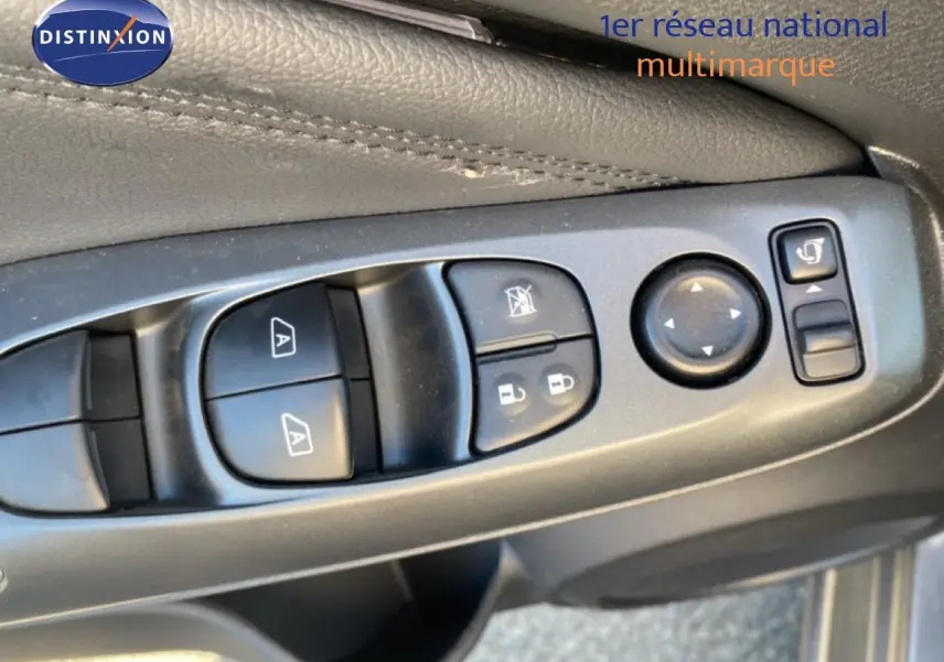 Gros plan sur les commandes de lève-vitres et réglages des rétroviseurs côté conducteur du Nissan Juke gris squale métal 2025.