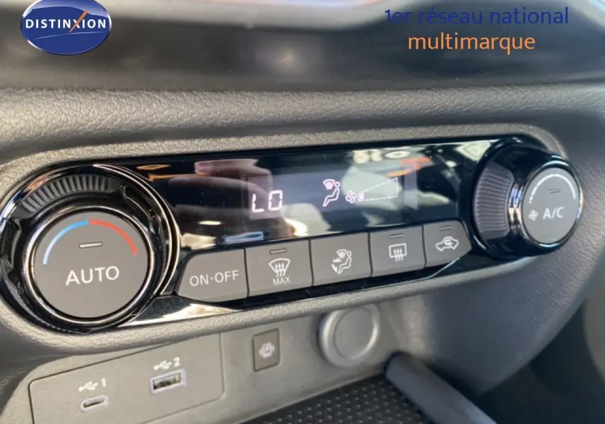 Gros plan sur la commande de climatisation automatique du Nissan Juke gris squale métal avec toit noir, affichage digital et boutons tactiles.