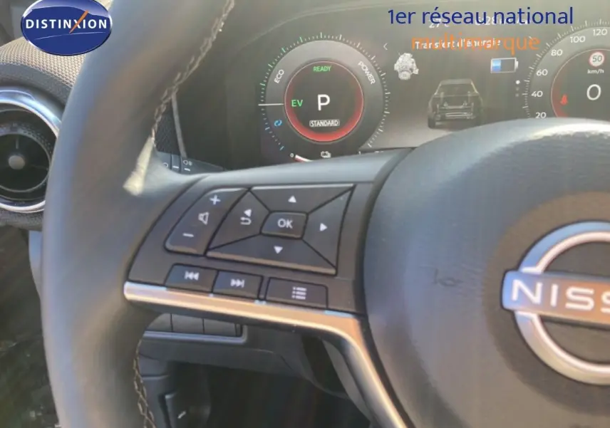 Gros plan sur le volant et le tableau de bord numérique du Nissan Juke 2025, avec commandes intégrées et affichage hybride.
