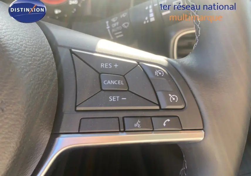Gros plan sur les commandes au volant à droite du Nissan Juke 2025, finition N-Sport, avec cuir noir et boutons de régulateur de vitesse.