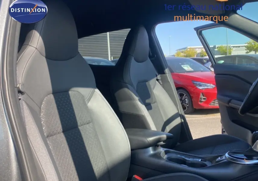 Vue intérieure côté gauche montrant les sièges avant en tissu noir du Nissan Juke 1.6 Full Hybrid 2025.