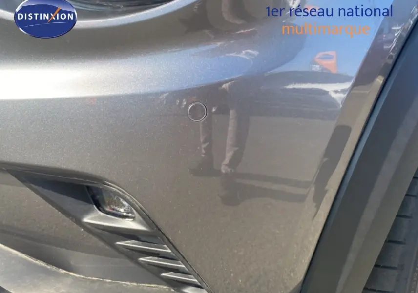 Gros plan sur l'avant droit gris squale métal du Nissan Juke 2025, mettant en valeur le pare-chocs et antibrouillard.