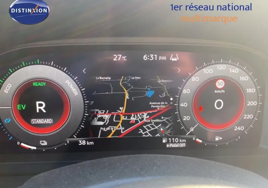 Tableau de bord numérique du Nissan Juke 2025 affichant la navigation, la vitesse à 0 km/h et le mode hybride EV.