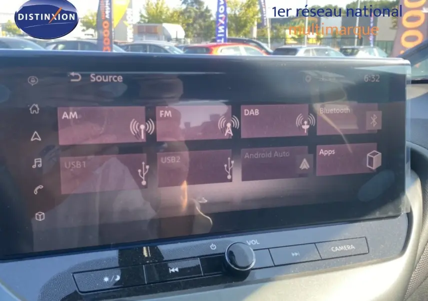 Vue rapprochée de l’écran tactile multimédia du Nissan Juke 2025 gris squale métal avec toit noir, affichant les sources audio.