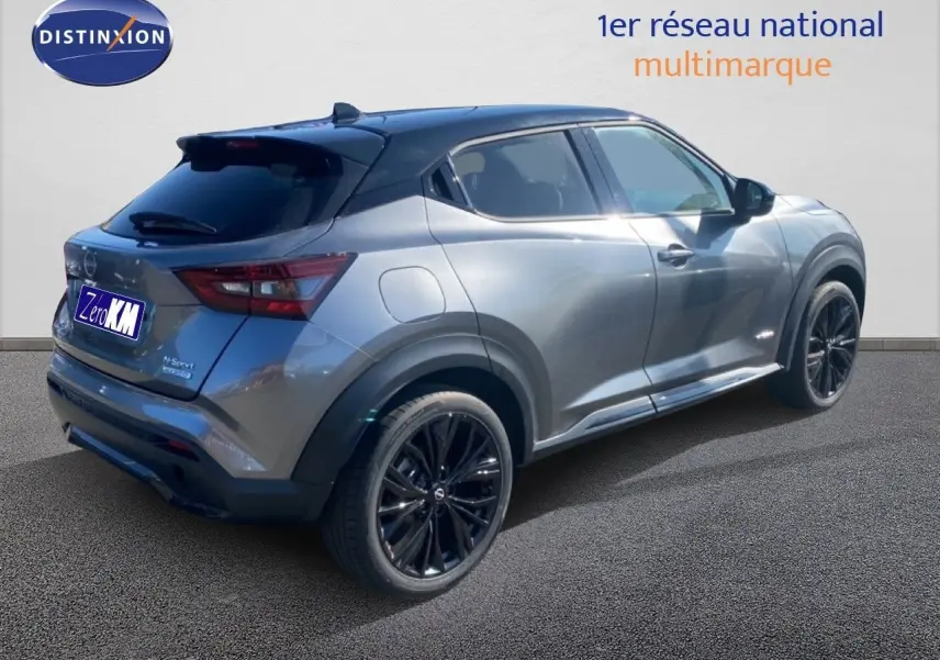 Vue 3/4 arrière droite du Nissan Juke 2025 gris squale métal avec toit noir et jantes noires sport.