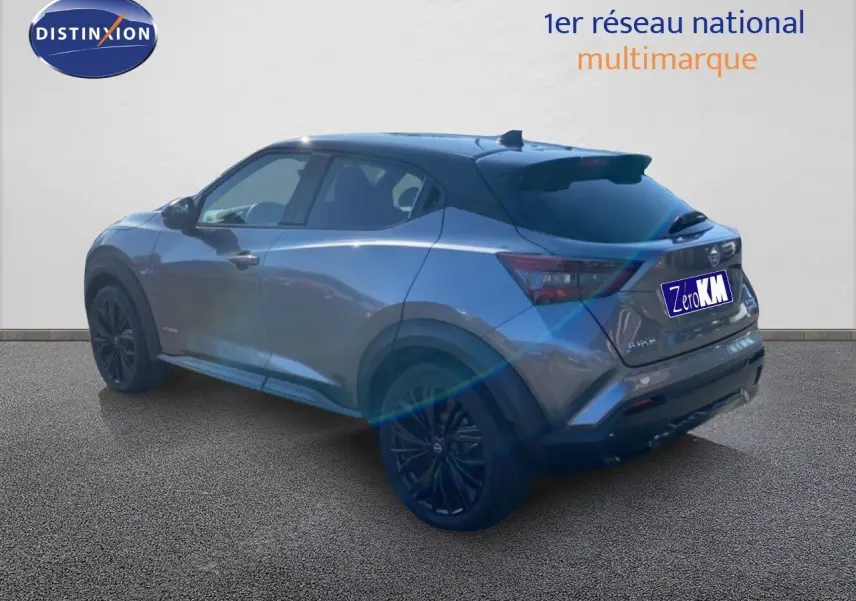 Nissan Juke 2025 gris squale métal avec toit noir, vue 3/4 arrière droit, jantes noires et lignes dynamiques.