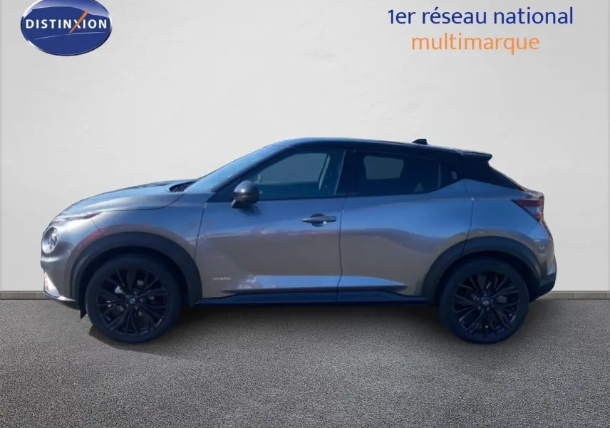 Vue latérale droite du Nissan Juke 1.6 Full Hybrid gris squale métal avec toit noir et jantes noires.