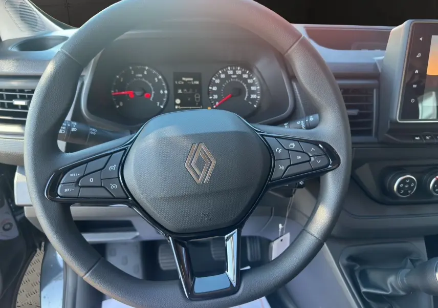 Vue rapprochée du volant multifonction noir et du tableau de bord du Renault Trafic Combi 2025 gris Comète.
