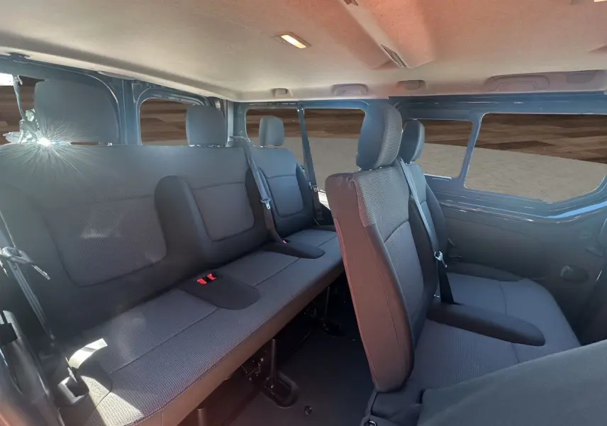 Intérieur du Renault Trafic Combi gris comète, vue latérale droite sur les sièges tissu noir et banquette arrière.
