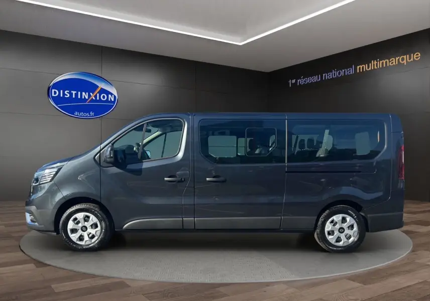 Profil latéral droit du Renault Trafic Combi gris comète 2025 avec portes coulissantes vitrées et jantes tôlées 16 pouces.