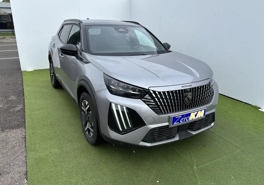Peugeot 2008 gris Artense toit noir en 3/4 avant droit, calandre noire à liserés chromés et feux LED griffés visibles.