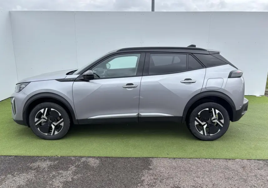 Profil côté gauche du Peugeot 2008 gris Artense avec toit noir, jantes bi-ton et lignes anguleuses modernes.