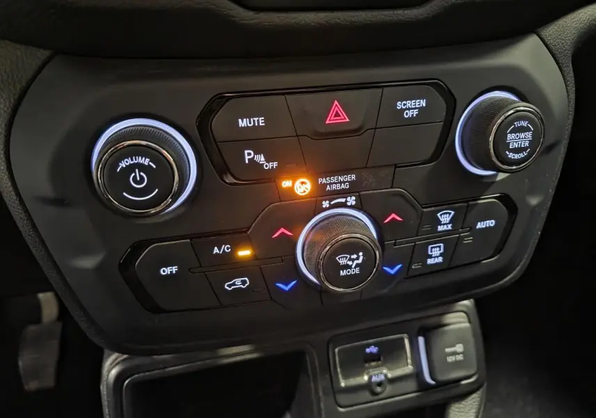 Gros plan sur la console centrale noire du Jeep Renegade 2018 avec commandes climatisation et multimédia éclairées.