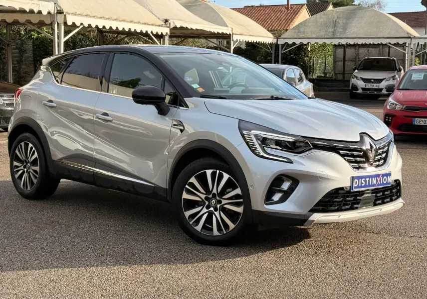 Renault Captur gris Highland en 3/4 avant droit, avec jantes alliage et calandre chromée distinctive.