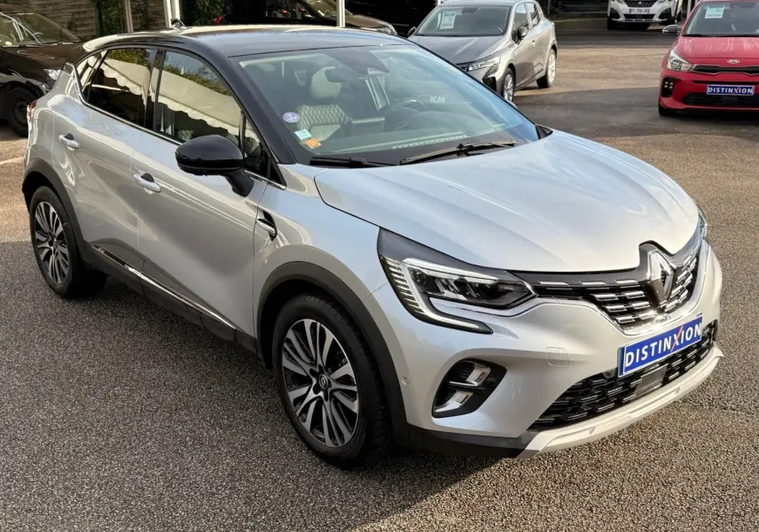Renault Captur gris Highland en 3/4 avant droit, avec toit noir et jantes alliage distinctives.