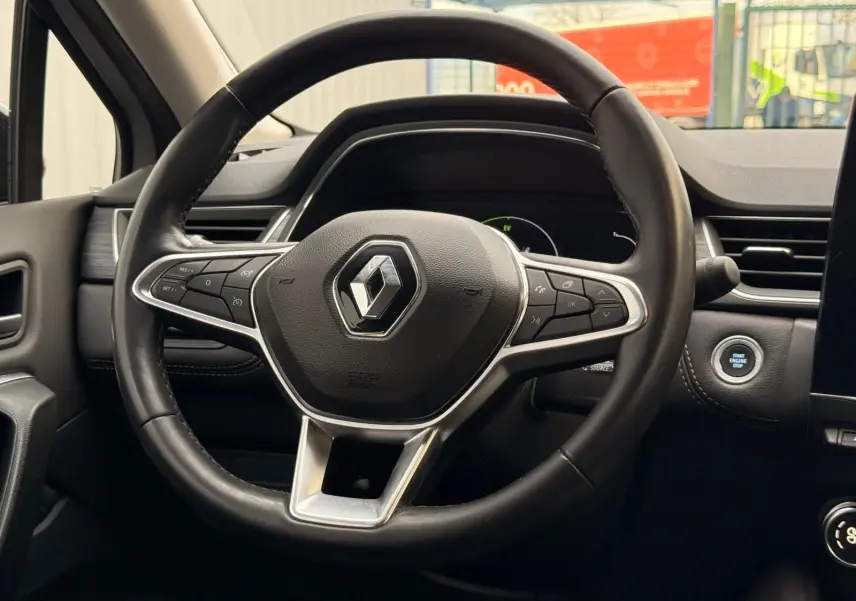 Vue rapprochée du volant cuir noir du Renault Captur 1.6 E-Tech hybride 2021 avec bouton démarrage visible.