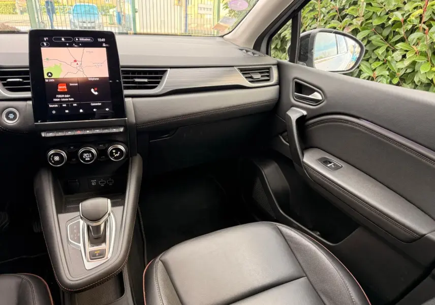 Intérieur du Renault Captur 1.6 E-TECH hybride 2021, vue côté passager avec console centrale et écran tactile noir.