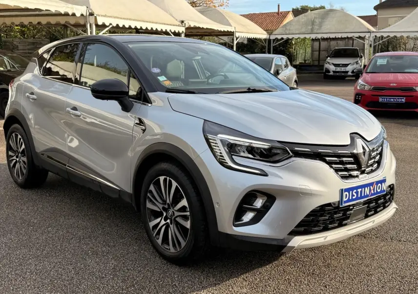 Renault Captur gris Highland en 3/4 avant droit, avec jantes alliage et calandre chromée brillante.