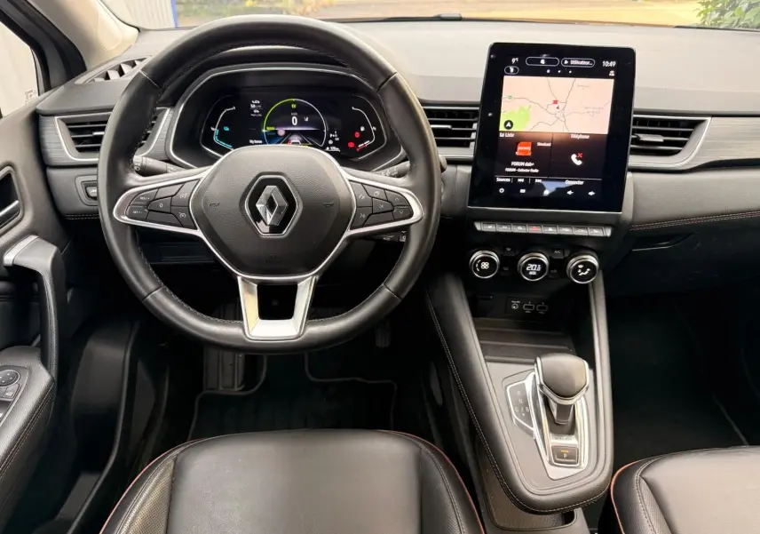 Intérieur Renault Captur 1.6 E-TECH hybride 2021, vue centrée sur le volant cuir et l'écran tactile avec navigation affichée.
