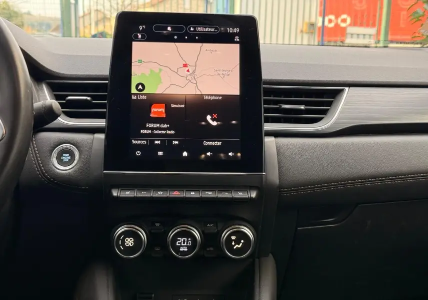 Vue centrale du tableau de bord du Renault Captur gris Highland 2021, avec écran tactile affichant la navigation et commandes climatiques.